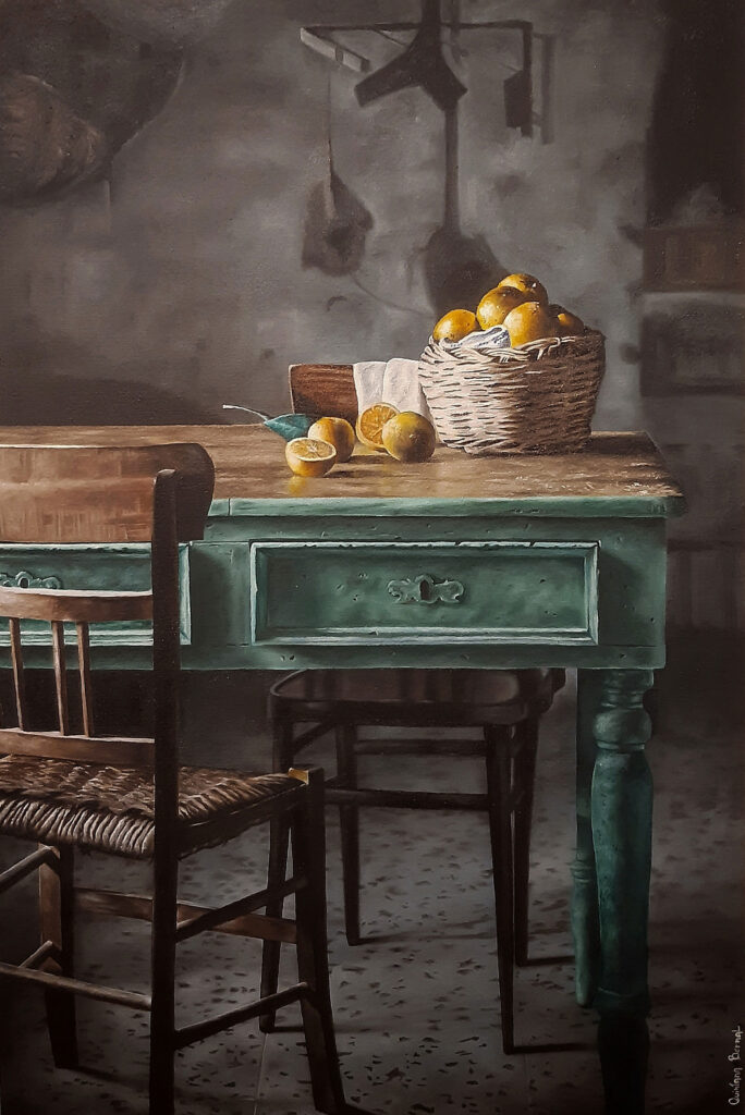 obra realista pintada por el artista visual Quintana Bernal que muestra una escena de campo donde hay una mesa rústica y un canasto con naranjas todo en claroscuro